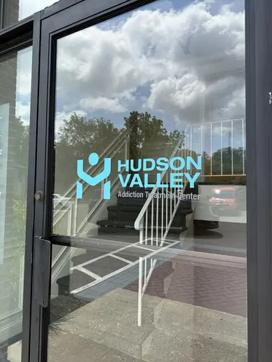 Glass entrance door with logo of Hudson Valley Addiction Treatment Center, partial hospitalization program in Bronx.
