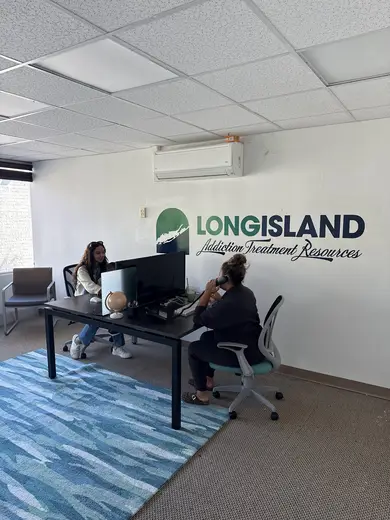 Modern office space with two women discussing at a desk, Long Island Addiction Treatment Resources partial hospitalization program in Bronx.